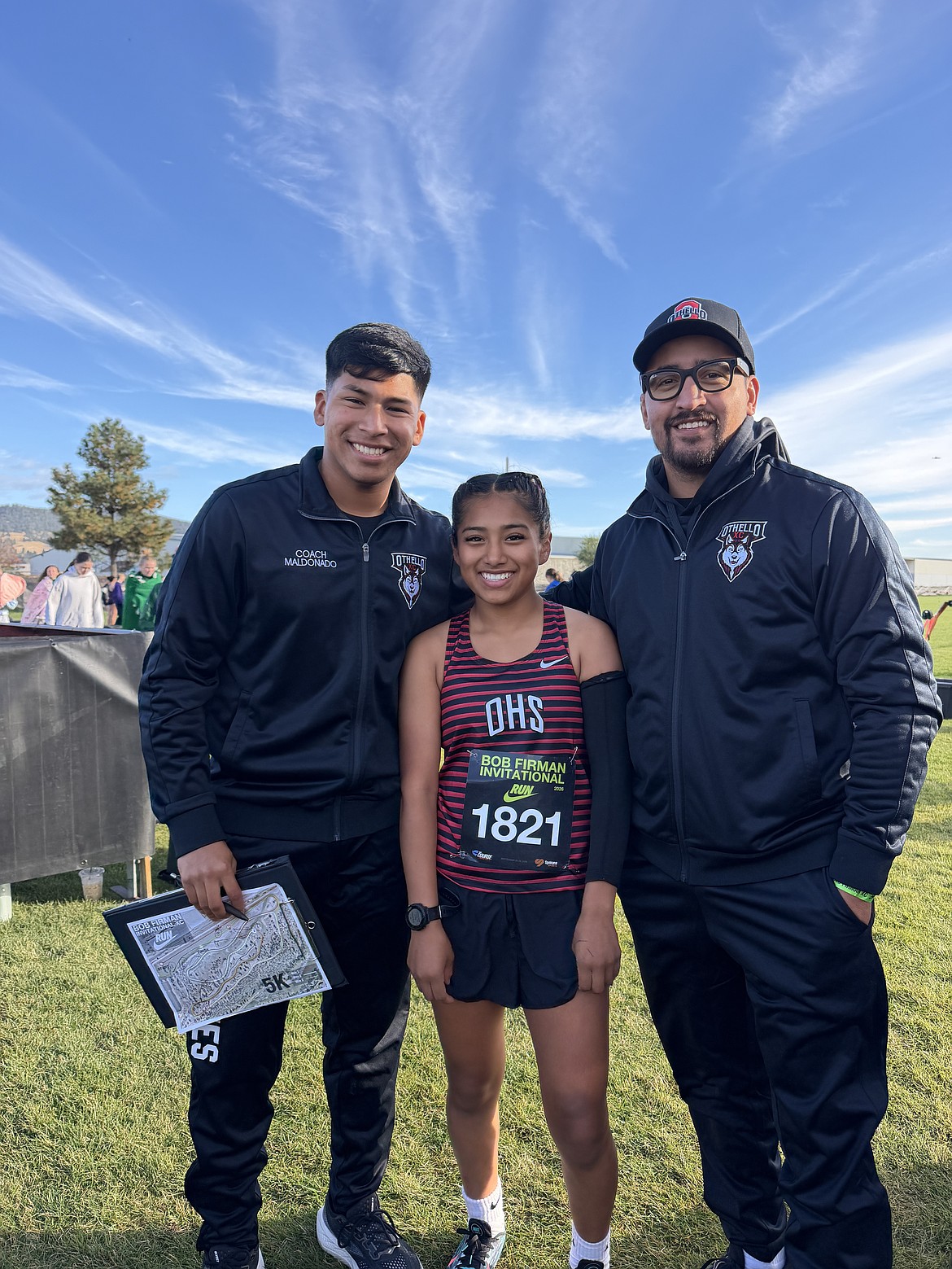 Huskies Head Coach David Maldonado, freshman Hermione Policarpio and Assistant Coach Reuben Lopez take a photo together after Policarpio finished with a time of 21:51.9 at the Nike Bob Firman Invitational.