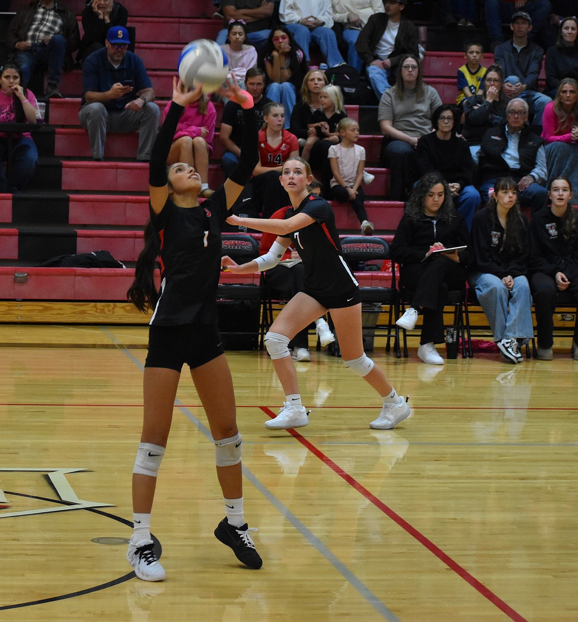 Huskies junior Keilani Segura (1) sets up the ball for her teammates while senior Amber Freeman (7) keeps an eye on the ball.