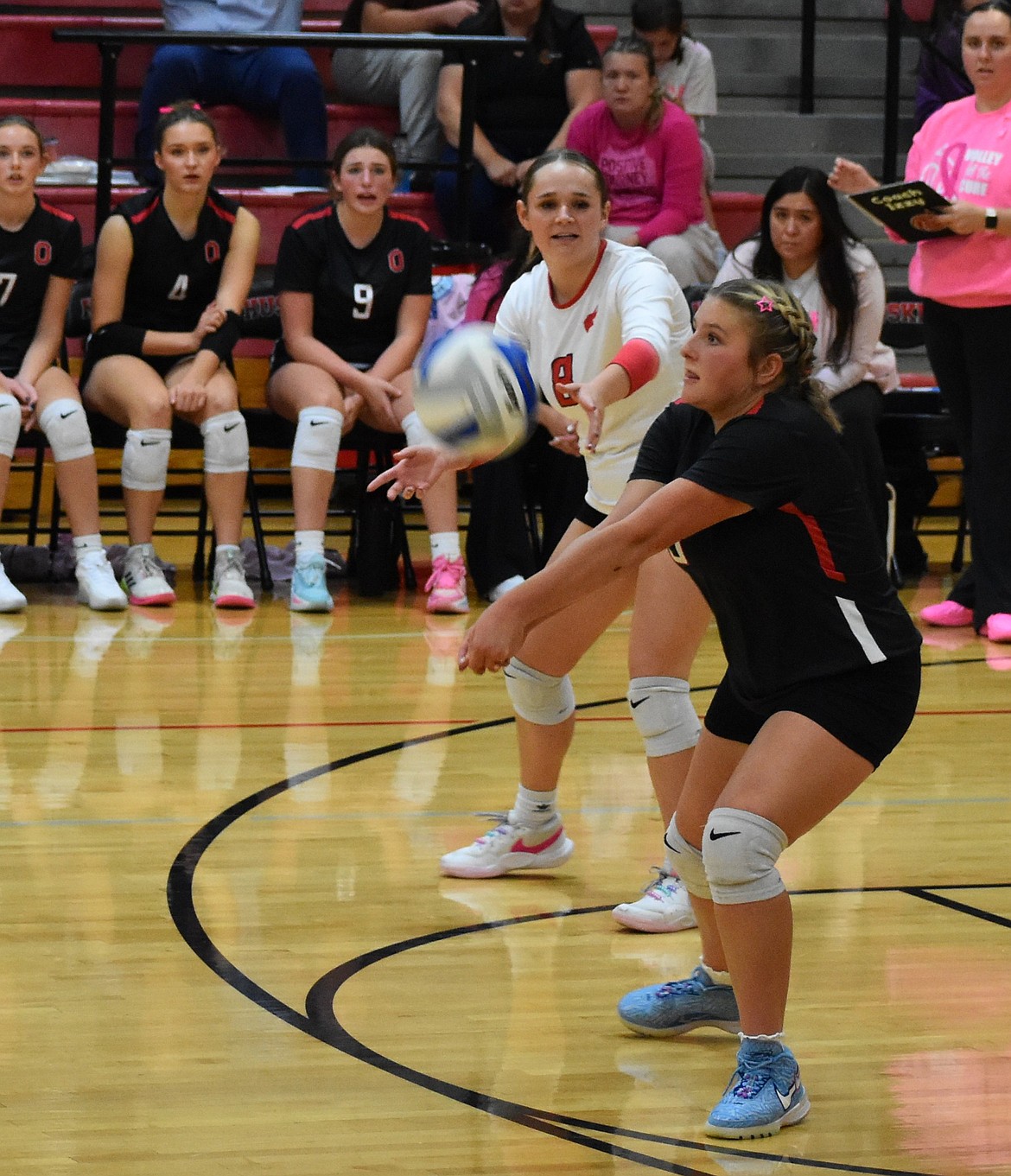 Addie Roylance (5), a senior for the Huskies, hits the ball and senior Hazel Roylance (8) communicates to the team.