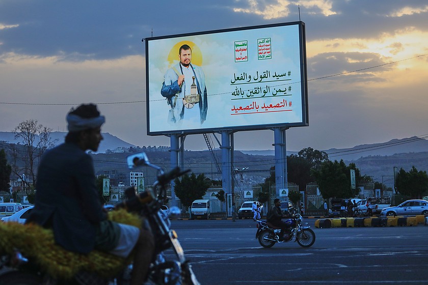 People ride their motorbikes under a billboard showing Houthi leader Abdul Malik al-Houthi with a phrase that reads in Arabic; "master of words and deeds." A Richland electrical engineer with the Department of Energy has been arrested on charges of supporting Houthi rebels with drones and explosive materials.