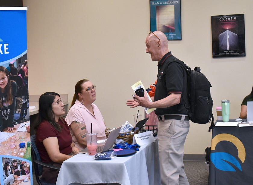 A job seeker talks with representatives from the Moses Lake School District at the Fall Hiring Event and Resource Fair Friday.