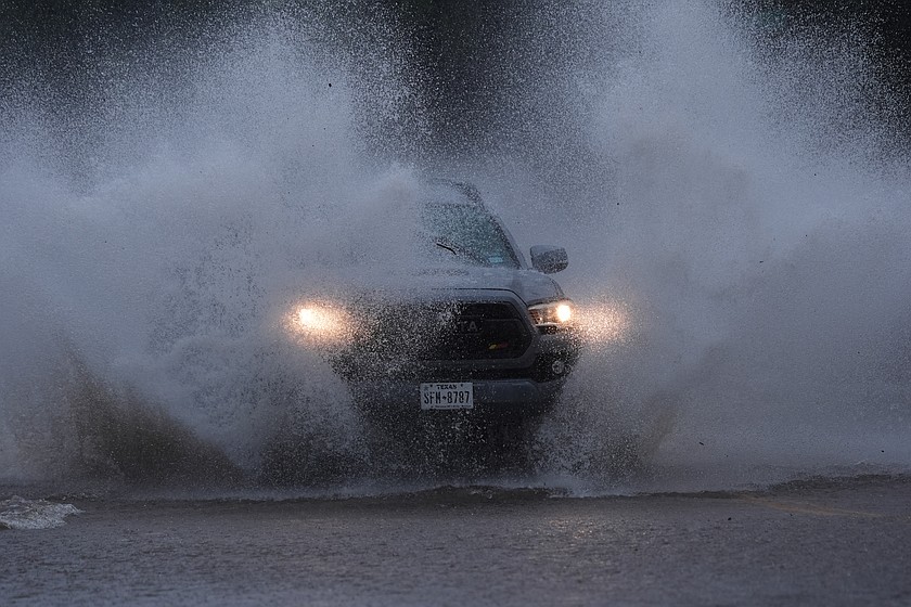 A vehicle navigates a flooded roadway as heavy rain move through the area, in San Antonio, Thursday, Oct. 1, 2026. (AP Photo/Eric Gay)