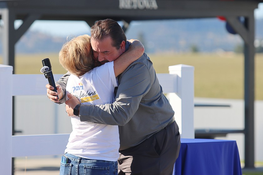 Maggie Lyons, Panhandle Affordable Housing Alliance executive director, hugs Jason Webb, of Grounded Solutions Network, at the Miracle on Britton neighborhood in Post Falls on Saturday.