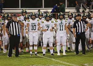 The Jacks’ Clinton Tuttle (10), Conner Galloway (7) and Jody Gardner (11) lock arms as they take the field for the coin toss ahead of their game against the Othello Huskies on Friday.