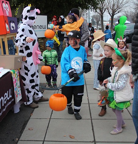 A hockey player has found a clever way to carry his candy basket at Quincy’s Downtown Trick-or-Treat.