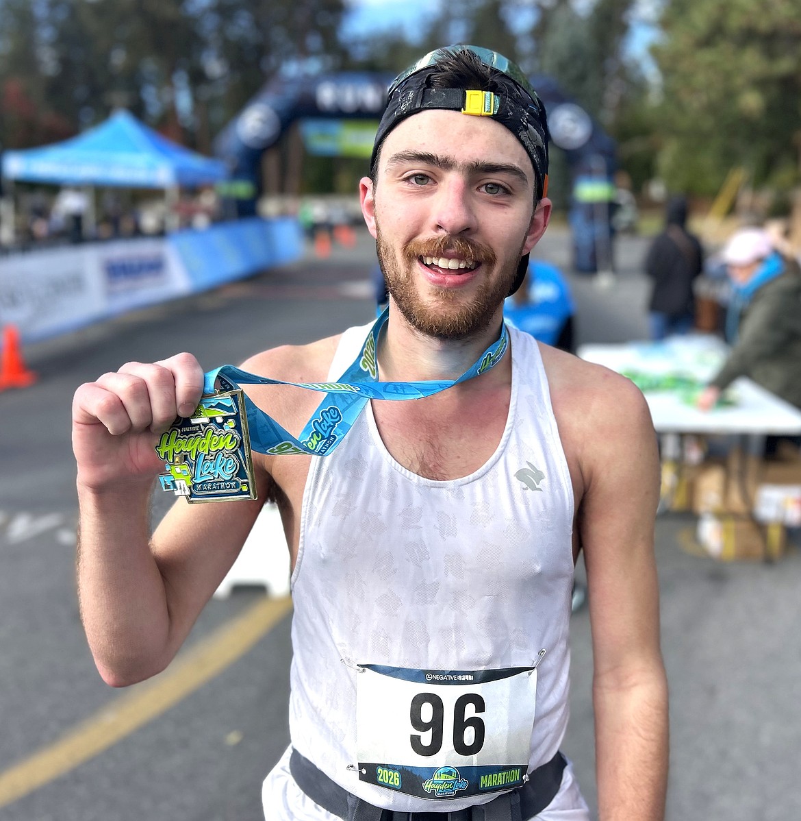 Ethan Garner of Coeur d'Alene holds up his medal after winning the Hayden Lake Marathon on Saturday.