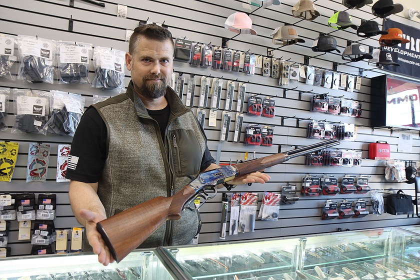 Brian Thomson, general manager of East County Guns in Coeur d'Alene, holds a Winchester Model 1873 lever-action rifle on Monday.