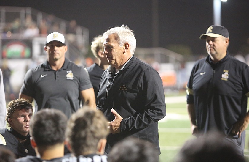 The Royal Knights Head Coach Wiley Allred (standing) talks with his players after a win earlier this season. With their 75-0 win over Naches Valley, the Knights officially set a new school record for their longest win streak (54).