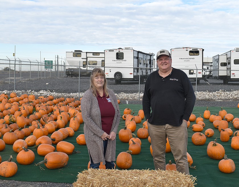 Clickit RV Finance Manager Jen Lonas, left, and General Manager Clint Monk stand in front of the impromptu pumpkin patch at the RV lot east of Moses Lake. The pumpkins will be given away the next two weekends; the pumpkin patch also will have games for the kids.