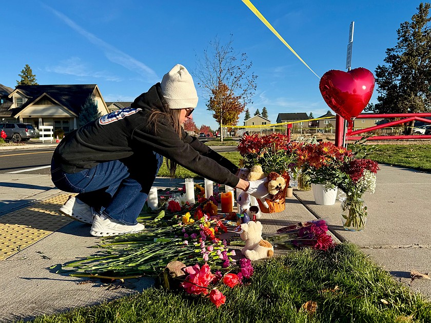 A person places flowers at a makeshift memorial on the other side of Silver Rail Elementary School in Bend, Ore., on Friday, Oct. 16, 2026, a day after a deadly shooting. (AP Photo/Haven Daley)