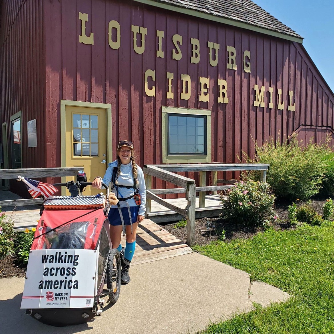 For most of her journey, Samantha Lee has carried behind her a cart for her things. She nicknamed it "Puff the tragic wagon." Here she is pictured at the Louisburg Cider Mill, a family-farm located in Louisburg, KS.