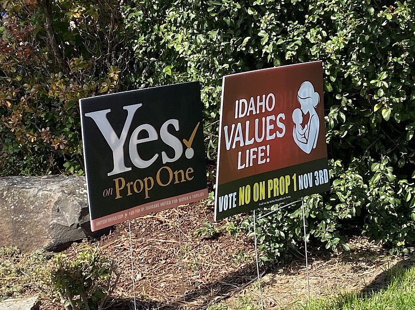 Opposing signs for and against Prop 1 on either side of a property line in Coeur d'Alene.