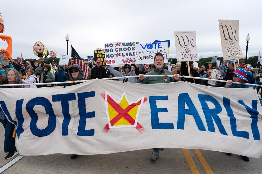 Demonstrators hold up banners as they march across the Memorial Bridge during a "No Kings" protest in Washington, Saturday, Oct. 17, 2026. (AP Photo/Jose Luis Magana)