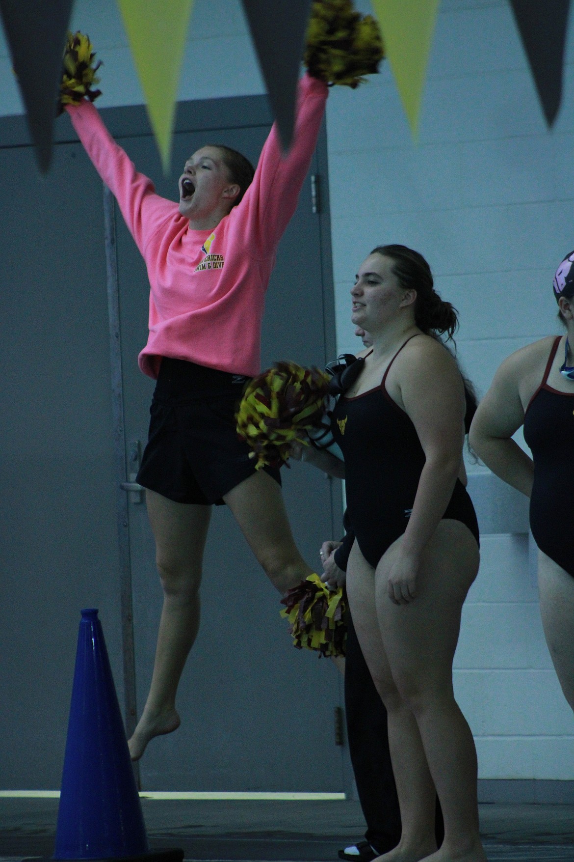 Ellen Center and Ally Hindman from MLHS cheer for their teammates from the edge of the pool Thursday evening.