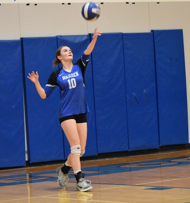 Warden senior Ella Chamberlain tosses up the ball as she serves during Tuesday's game against Tri-Cities Prep.
