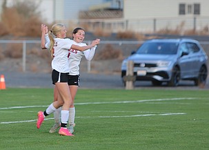 The Huskies' Brooklyn Hillman (right) embraces teammate Paisley Sly (left) after she scored for the Huskies on Tuesday.