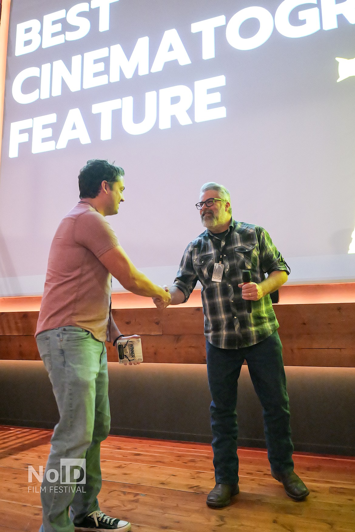 Matt Edwards shakes hands with an award winner at the North Idaho Film Festival.